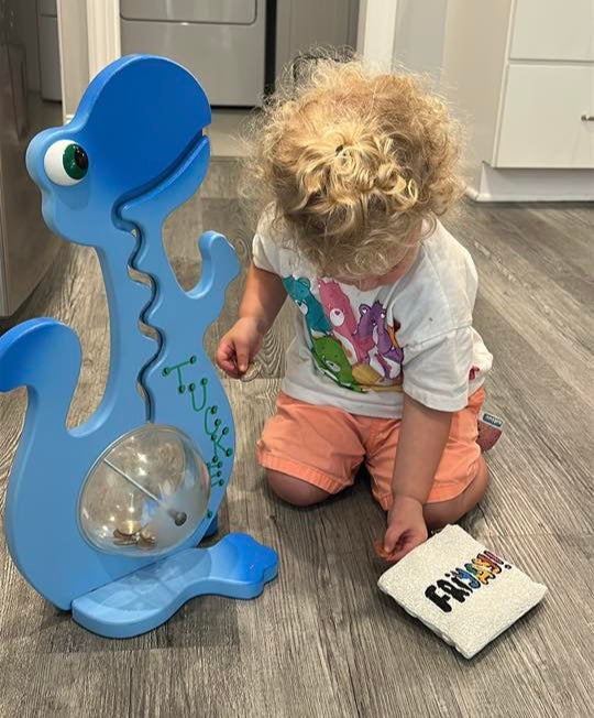 Child playing with a big belly banks in a kitchen
