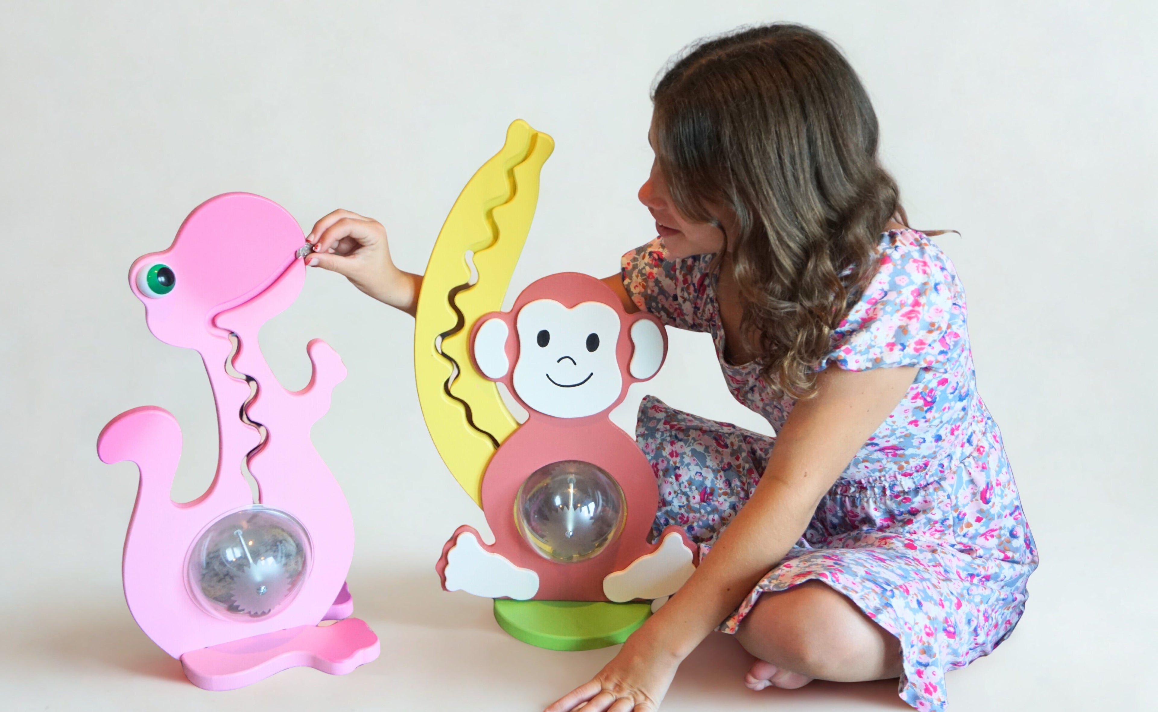 Child playing with colorful monkey and dino bank