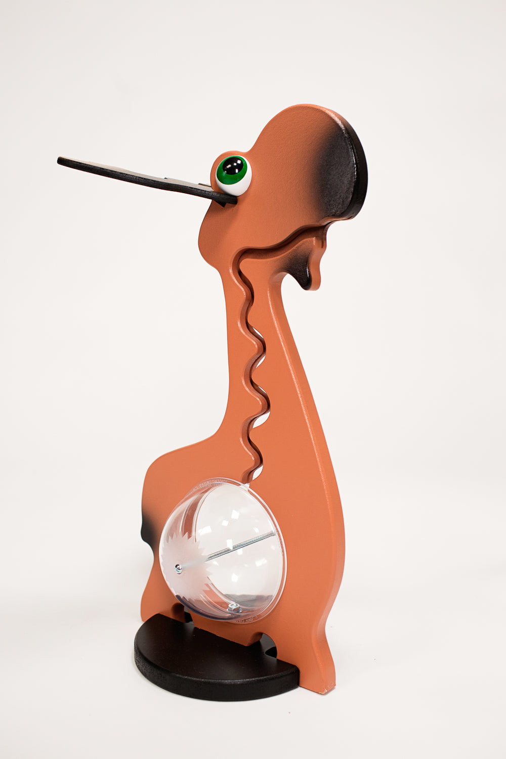 Side view of an orange moose Big Belly Banks toy bank with antlers, a green eye, and a clear belly coin compartment on a black base.
