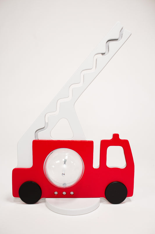 A red fire truck piggy bank with a coin track on its side and black wheels.